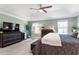 The primary bedroom offers a spacious layout, a tray ceiling, comfortable bed, and a TV with closet on the side at 7729 Calcutta Dr, Willow Springs, NC 27592