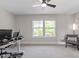 A bright office features neutral walls, carpet, a large window, minimalist desk with computer equipment, and a comfy chair at 7729 Calcutta Dr, Willow Springs, NC 27592