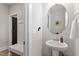 A modern powder room features a pedestal sink with a decorative mirror and convenient coat rack and storage bench at 7729 Calcutta Dr, Willow Springs, NC 27592