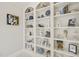 Built-in white shelves displaying various decorative items, art pieces, and books, adding character at 8524 Society Pl, Raleigh, NC 27615