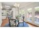 Bright dining area featuring a glass table, skylights, and access to a private brick-paved patio at 8524 Society Pl, Raleigh, NC 27615