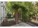Garden gate entrance framed by lush greenery and brick columns at 8524 Society Pl, Raleigh, NC 27615