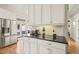 Stylish kitchen with stainless steel refrigerator, black countertops, and white cabinets at 8524 Society Pl, Raleigh, NC 27615