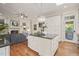 Open-concept kitchen featuring a large island, chandelier, hardwood floors, and seamless flow to living area at 8524 Society Pl, Raleigh, NC 27615
