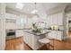 Bright kitchen with a large island, chandelier, stainless steel appliances, and hardwood floors at 8524 Society Pl, Raleigh, NC 27615