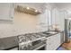 Gourmet kitchen features stainless steel appliances, white cabinetry, and custom backsplash at 8524 Society Pl, Raleigh, NC 27615