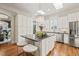 Spacious kitchen featuring a center island, stainless steel appliances, hardwood floors, and bright, natural light at 8524 Society Pl, Raleigh, NC 27615
