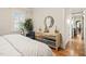 View of a bright main bedroom featuring a mirrored dresser, hardwood floors, and a blue arm chair at 8524 Society Pl, Raleigh, NC 27615