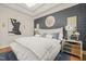 Main bedroom featuring patterned wall, hardwood floors and a king size bed at 8524 Society Pl, Raleigh, NC 27615