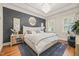 Main bedroom with patterned wall, hardwood floors, white furnishings, and a chandelier at 8524 Society Pl, Raleigh, NC 27615