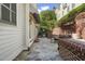 Exterior patio featuring stone flooring, brick accents, and lush plants with a dining set and grill at 8524 Society Pl, Raleigh, NC 27615