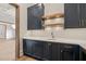 Stylish bar featuring dark blue cabinetry, wooden shelves, and gold hardware at 9004 Meadow Pointe Ct, Wake Forest, NC 27587