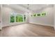 Bright bedroom features large windows with a treelined view, hardwood floors, and a ceiling fan at 9004 Meadow Pointe Ct, Wake Forest, NC 27587