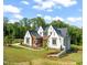 Stunning modern home features white brick, wood accents, dark roof and professionally landscaped yard at 9004 Meadow Pointe Ct, Wake Forest, NC 27587