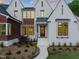 Inviting home with white brick, striking black trim, and a welcoming entrance framed by mature landscaping at 9004 Meadow Pointe Ct, Wake Forest, NC 27587