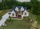 Stunning exterior elevation of a modern home with a manicured lawn and a three car garage at 9004 Meadow Pointe Ct, Wake Forest, NC 27587