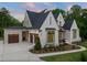 Elegant home showcasing multiple garage doors, a brick exterior, and manicured landscaping, offering both beauty and practicality at 9004 Meadow Pointe Ct, Wake Forest, NC 27587