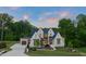 Beautiful home featuring a manicured lawn, white brick, contrasting dark trim, and a convenient circular driveway at 9004 Meadow Pointe Ct, Wake Forest, NC 27587