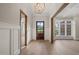 Bright foyer with dark wood door, wood beam accents, wainscoting, chandelier, and light wood floors at 9004 Meadow Pointe Ct, Wake Forest, NC 27587