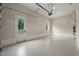 The spacious garage features an epoxy floor, pedestrian door, and neutral paint at 9004 Meadow Pointe Ct, Wake Forest, NC 27587