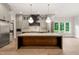 Bright kitchen with stainless steel appliances, large island with white countertop and hardwood floors at 9004 Meadow Pointe Ct, Wake Forest, NC 27587