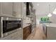 Kitchen with stainless steel microwave, matching appliances, white backsplash, hardwood floors, and decorative lighting at 9004 Meadow Pointe Ct, Wake Forest, NC 27587