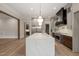 Bright kitchen featuring a large island with quartz countertop, stainless steel fridge and hardwood floors at 9004 Meadow Pointe Ct, Wake Forest, NC 27587
