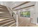 Spacious living room featuring exposed wood beams, large sliding doors to the patio, and stairs to the second floor at 9004 Meadow Pointe Ct, Wake Forest, NC 27587