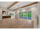Open-concept living room with wood beams, fireplace, access to patio, and view of the kitchen at 9004 Meadow Pointe Ct, Wake Forest, NC 27587
