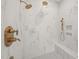 Bright tile shower with gray tile floors, a bench, and gold fixtures at 9004 Meadow Pointe Ct, Wake Forest, NC 27587