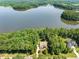 Stunning aerial view of a home nestled among lush trees, overlooking a serene lake at 901 Edgewater Dr, Garner, NC 27529