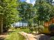 Landscaped backyard featuring a lake view, lush lawn, and a charming wooden walkway at 901 Edgewater Dr, Garner, NC 27529