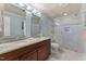 Bathroom features dual sinks, granite counters, and a glass-enclosed shower with attractive neutral tile at 901 Edgewater Dr, Garner, NC 27529