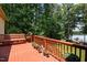 Outdoor deck with a wooden bench, potted plants, and railing, offering scenic views of the lush backyard at 901 Edgewater Dr, Garner, NC 27529
