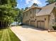 Tan home features a three-car garage and a lake view at 901 Edgewater Dr, Garner, NC 27529