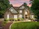 Elegant home with stone accents, manicured landscaping, and a warm, inviting facade at 901 Edgewater Dr, Garner, NC 27529