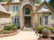 Close up of home's inviting front entrance showcasing stone and a carved wooden door at 901 Edgewater Dr, Garner, NC 27529