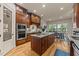A gourmet kitchen boasts custom wood cabinets, stainless steel appliances, and a granite island with sink at 901 Edgewater Dr, Garner, NC 27529