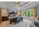 Opulent main bedroom with a decorative ceiling, a king-sized bed, and large windows overlooking lush scenery at 901 Edgewater Dr, Garner, NC 27529