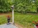 Expansive backyard features green grass, mature trees, and a decorative bell at 967 Bynum Rd, Pittsboro, NC 27312