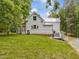 Backyard with a deck, landscaping, stairs and green grass at 967 Bynum Rd, Pittsboro, NC 27312