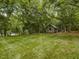Picturesque backyard with a quaint shed nestled among mature trees and a lush green lawn at 967 Bynum Rd, Pittsboro, NC 27312