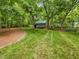 Backyard showing a storage shed, trees and green grass at 967 Bynum Rd, Pittsboro, NC 27312