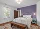 Charming bedroom featuring an iron bed frame, accent wall and a decorative area rug at 967 Bynum Rd, Pittsboro, NC 27312