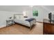 Bright bedroom boasts a large window, light walls, and a bed with a blue throw at 967 Bynum Rd, Pittsboro, NC 27312
