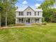 Charming two-story home with a covered porch and lush green lawn at 967 Bynum Rd, Pittsboro, NC 27312