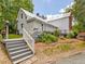 Exterior rear view of a quaint white home with multiple decks and levels in the backyard at 967 Bynum Rd, Pittsboro, NC 27312