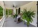 Inviting covered porch featuring a ceiling fan, rocking chairs, and lush ferns at 967 Bynum Rd, Pittsboro, NC 27312