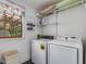 Laundry room with modern washer and dryer, wire shelving, and bright window at 967 Bynum Rd, Pittsboro, NC 27312