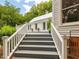 Stairway leading to the deck, accented with potted flowers, with a glimpse of the surrounding landscape at 967 Bynum Rd, Pittsboro, NC 27312